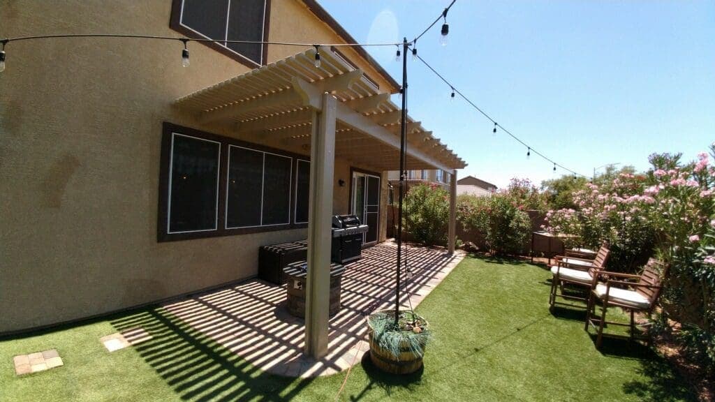 Lattice patio cover with string lights over a backyard