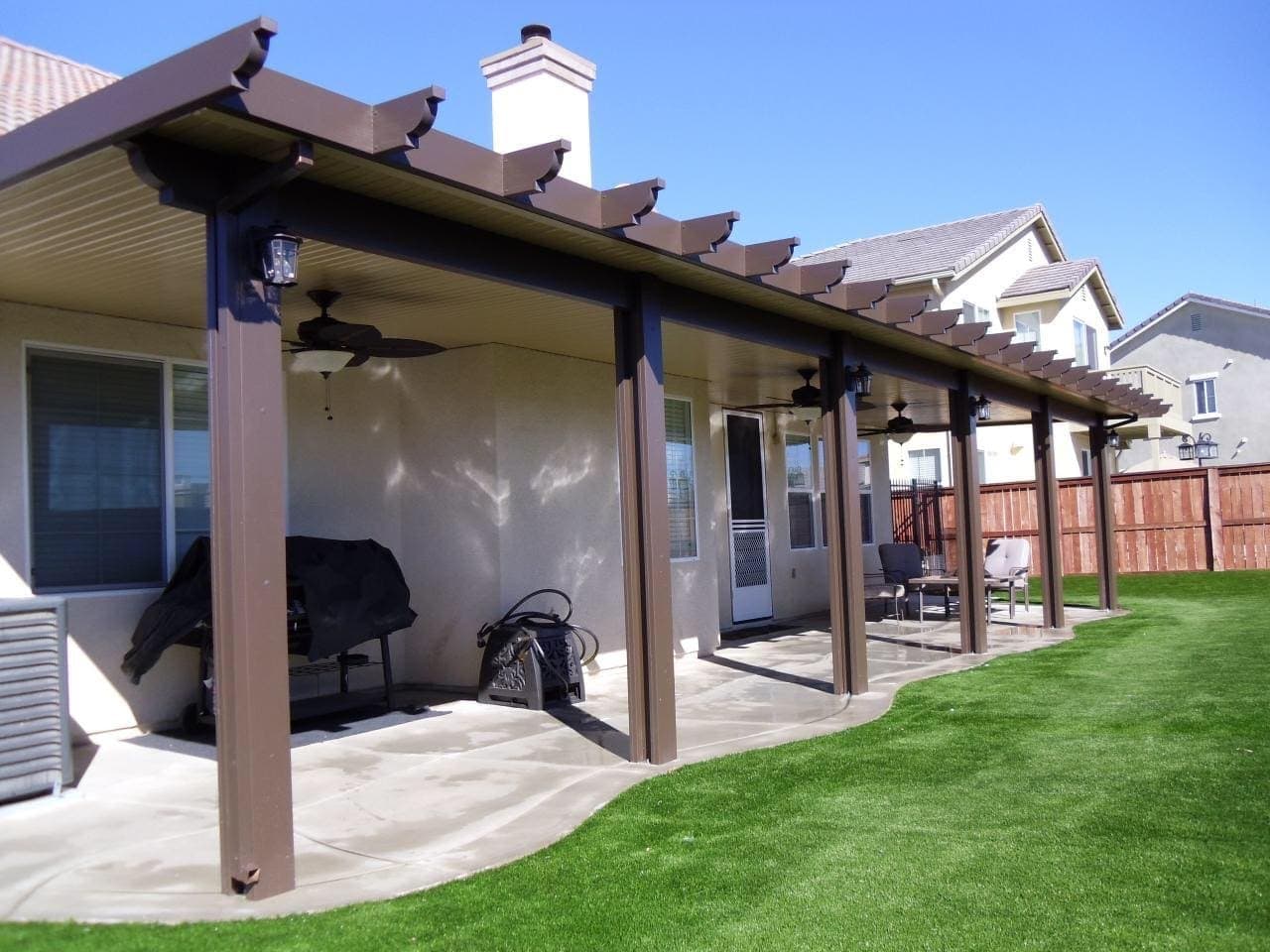 Solid patio cover with a ceiling fan over a lawn-side patio