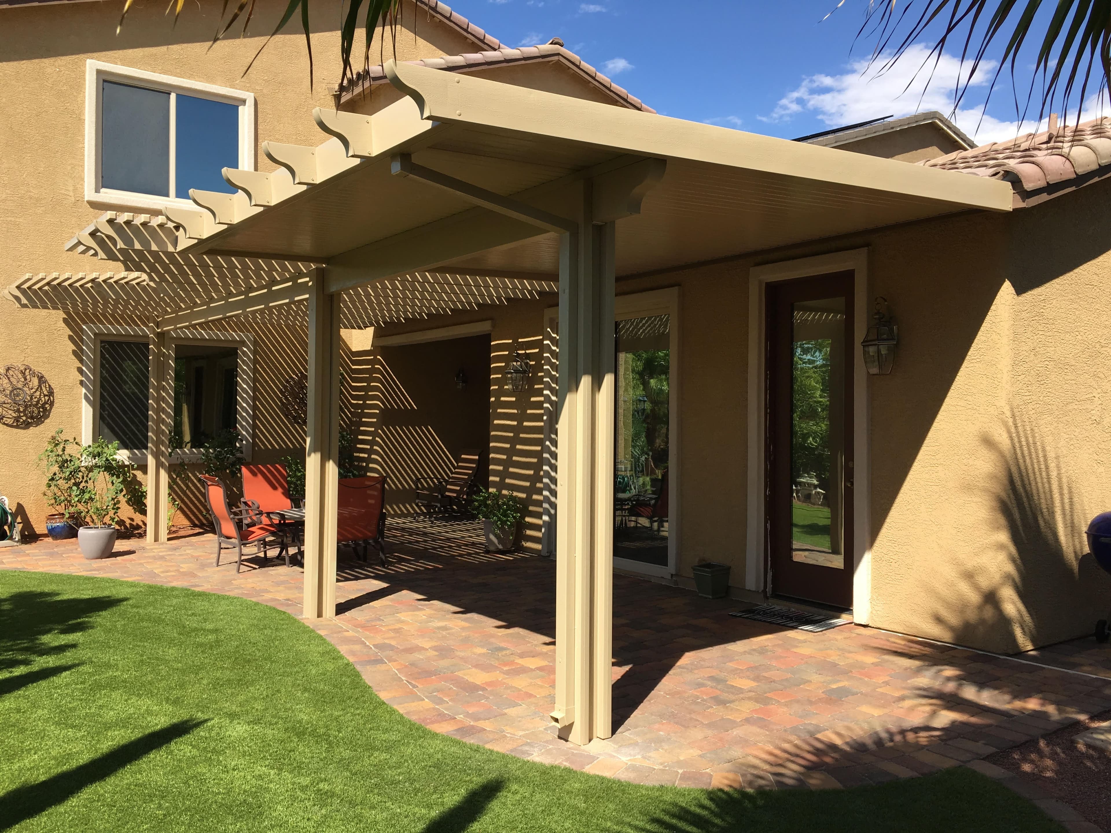 Lattice patio cover over a paver patio with red chairs